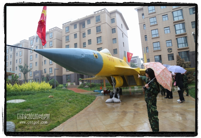 小區(qū)突然出現(xiàn)“飛機坦克”，其中殲15艦載戰(zhàn)斗機一架、99式主戰(zhàn)坦克一輛、武直-10武裝直升機一架，吸引了眾多市民雨中圍觀、合影。